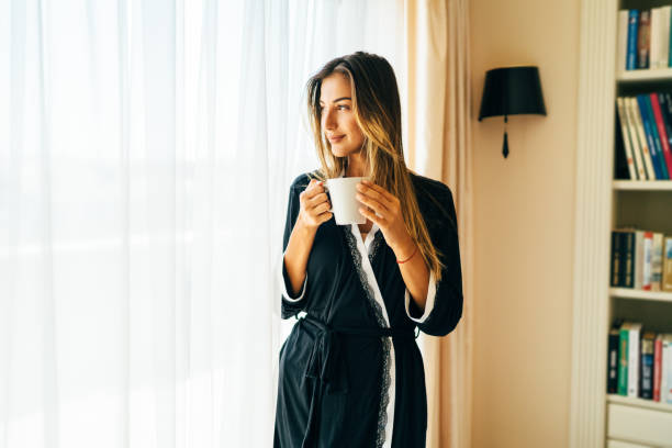 istock Woman drinking coffee at home 1211356274
