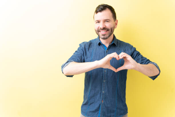 istock Happy Latin Man Is Showing Love Gesture 1211357320