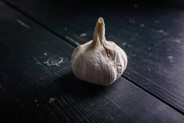 istock Bulbs of garlic on a dark background. Low key lighting 1211357831