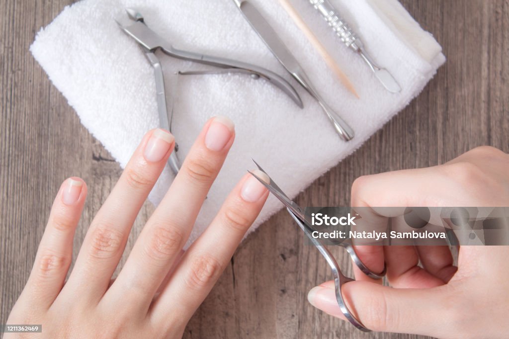 Trim The Nails On The Hand Do Yourself A Manicure Shorten Long Nails Home  Nail Care Spa Beauty Manicure Tools On A White Towel Procedure Nail Salon  Tweezers Nippers Pusher Orange Stick