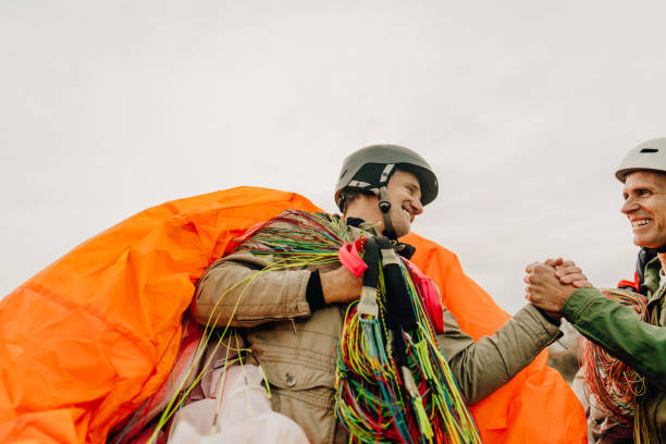 istock Senior men carrying their parachutes after the flight 1211363153
