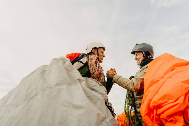Senior men carrying their parachutes after the flight