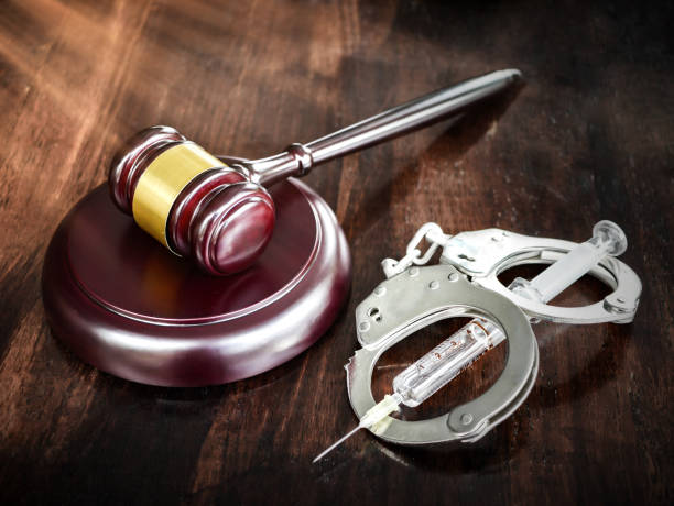 istock Judges gavel and syringe injection on wooden table 1211363514