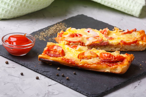 Pizza with tomatoes, cheese and tomato ketchup on a stone flat board - fotografia de stock