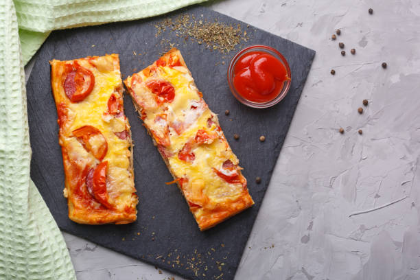 石の平板にトマト、チーズ、トマトケチャップのピザ ストックフォト