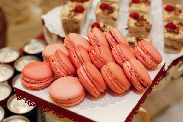 istock stylish pink macaroons, candy bar with sweets at luxury wedding reception. catering at restaurant. cupcakes  macarons with drinks on table. space for text 1211364792