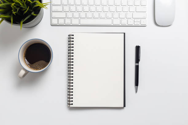 istock Top view, empty notebook and office supplies isolated on white background 1211365037