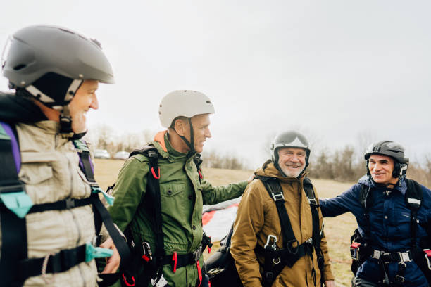 istock Old friends getting ready for the flight with a paraglider 1211365120