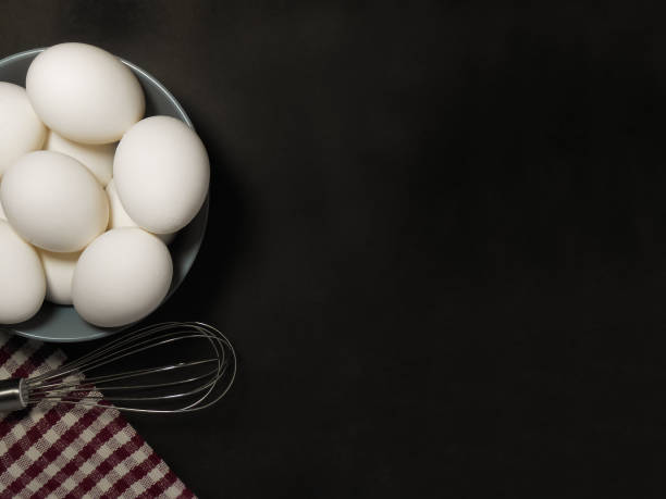 istock Cooking Ingredients eggs and kitchen textile in a black background. Copy Space. 1211368451