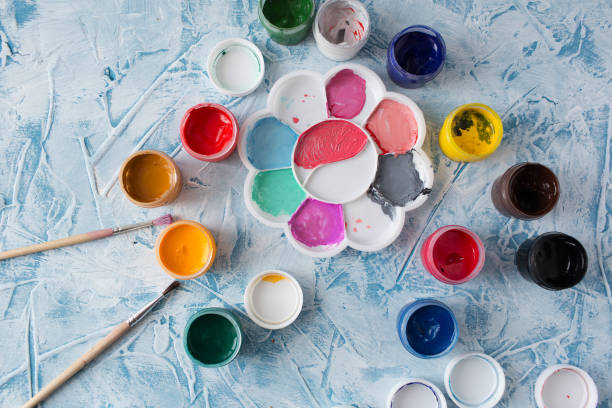 istock Gouache for drawing different colors with brushes on a gray texture background 1211368558