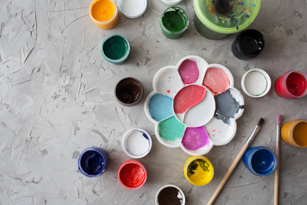 istock Gouache for drawing different colors with brushes on a gray texture background 1211368653