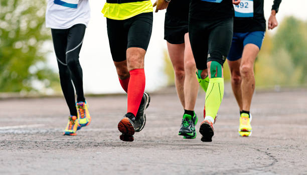 jambes coureurs masculins dans des chaussettes de compression - marathon running london england competition photos et images de collection