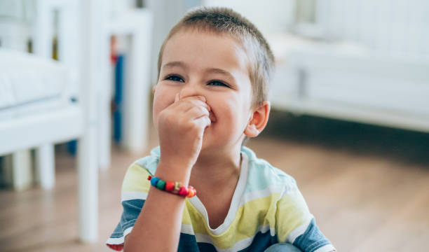 Little boy pinching his nose. Portrait of a cute little boy holding his nose for sign of bad smell. holding nose stock pictures, royalty-free photos & images