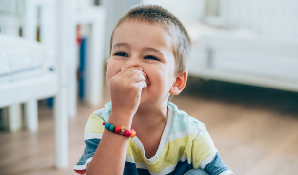 Little boy pinching his nose. Portrait of a cute little boy holding his nose for sign of bad smell. human nose stock pictures, royalty-free photos & images