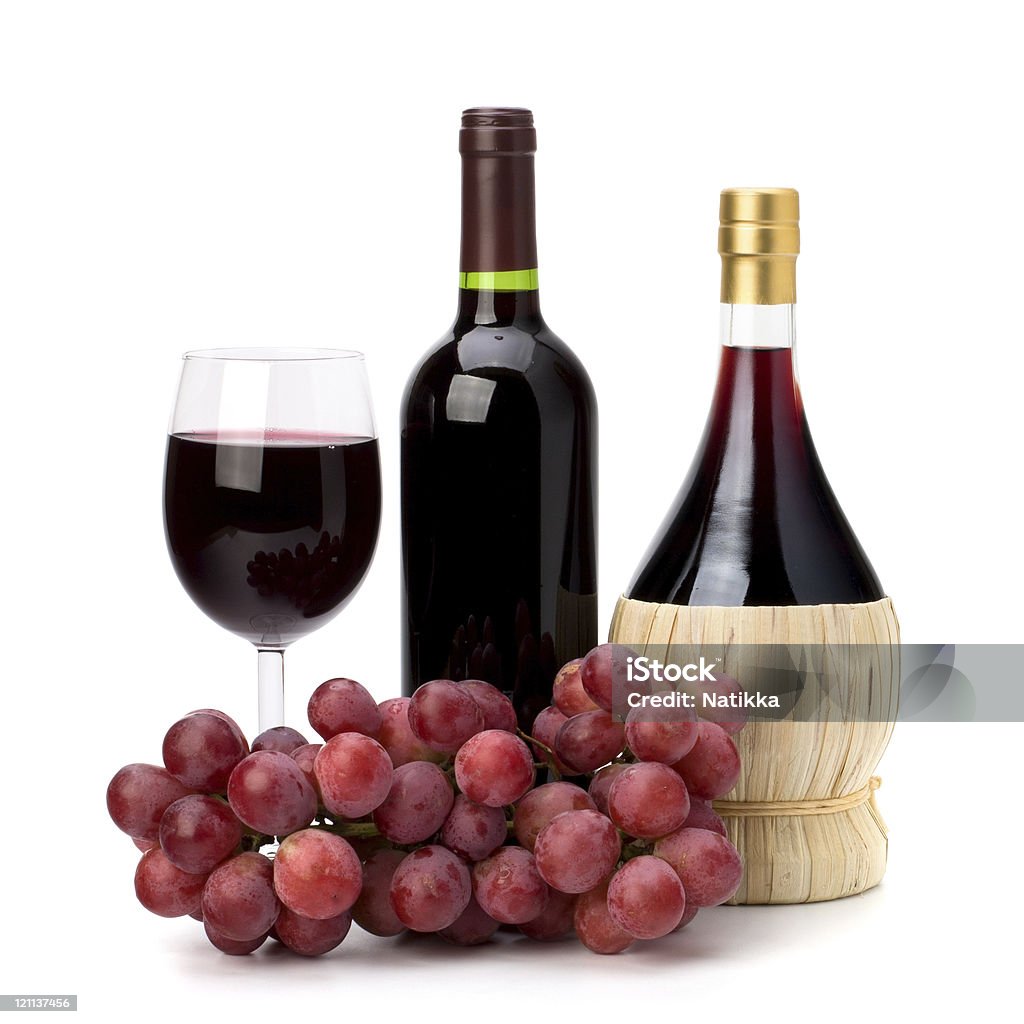 Un verre de vin rouge, verre et raisins, bouteilles - Photo de Fond blanc libre de droits