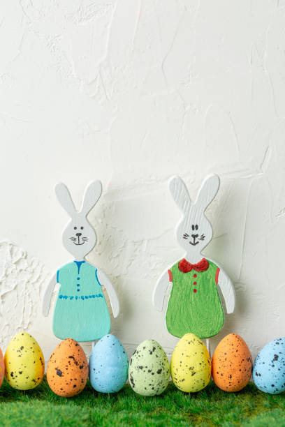 istock Wooden toy rabbits with colored Easter eggs. 1211376970