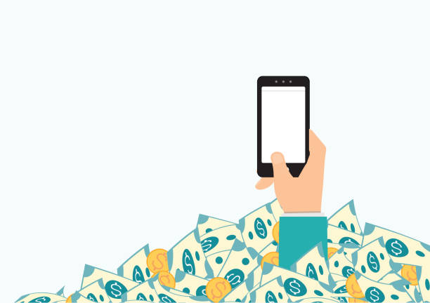 istock Hand holding smart phone in pile of money. 1211377025