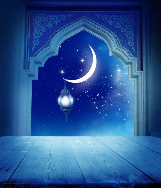 istock Ramadan Kareem background..Mosque window with shiny crescent moon and wooden table 1211377231