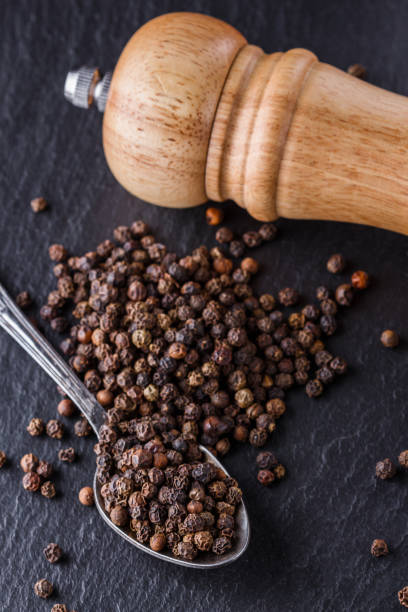 istock aromatic black pepper on a dark stone background 1211379167