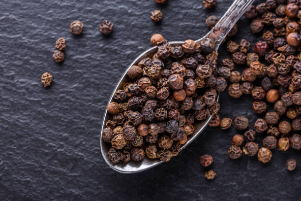 istock aromatic black pepper on a dark stone background 1211379278