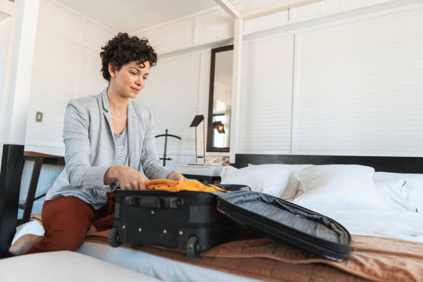 istock Woman packing her suitcase in bed 1211381235