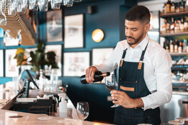 istock Waiter serving red wine at the hotel bar 1211381373