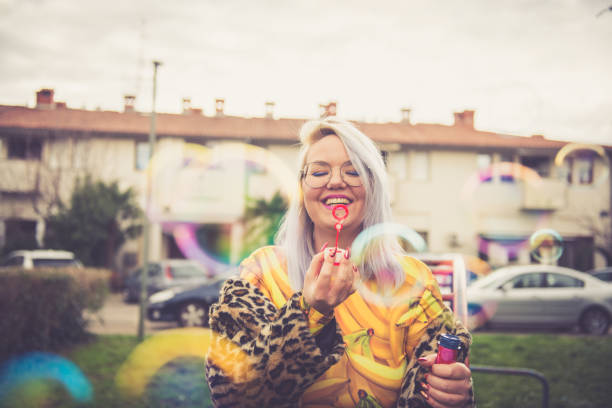 Colorful funky woman blowing soap bubbles
