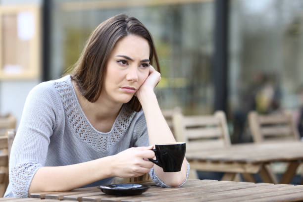 istock Sad young woman looking away on a restaurant terrace 1211384888