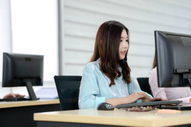 istock Beautiful smiling call center worker in headphones is working at modern office 1211385171