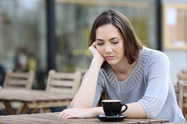 istock Sad girl looking down pensive on a cafe terrace 1211385260