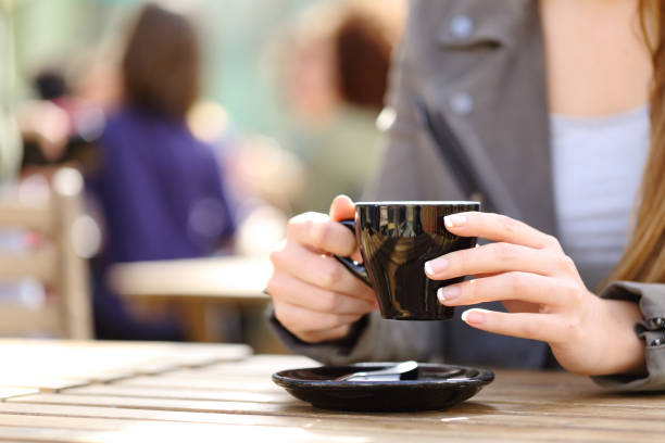 mulher segurando xícara de café em suas mãos em um terraço - coffee shop coffee break coffee cup holding - fotografias e filmes do acervo