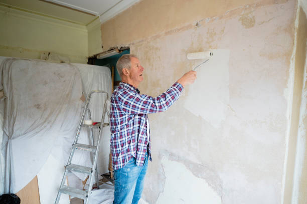 istock Man Painting Home with a Paint Roller 1211385363