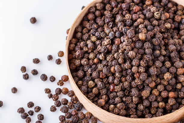 istock fragrant black pepper on white acrylic background 1211386136