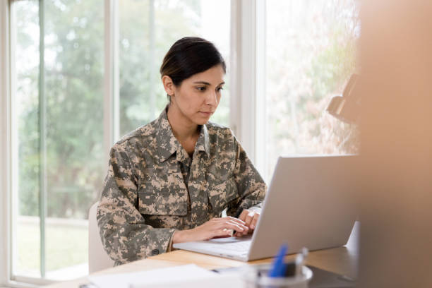 istock Female soldier concentrates while working from home 1211388302