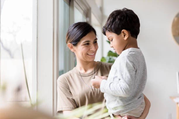 mid adult mom enjoys time with son - homecoming imagens e fotografias de stock