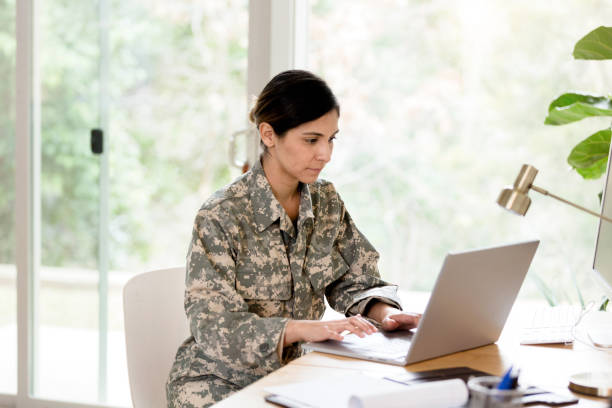 istock Female soldier telecommuting from home 1211388331