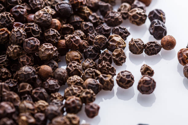 istock fragrant black pepper on white acrylic background 1211388482