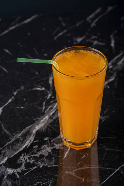 istock Orange juice on the black background 1211388527