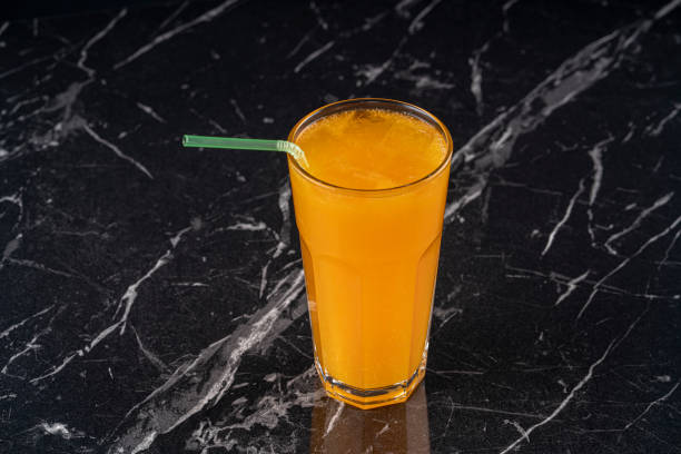 istock Orange juice on the black background 1211388574