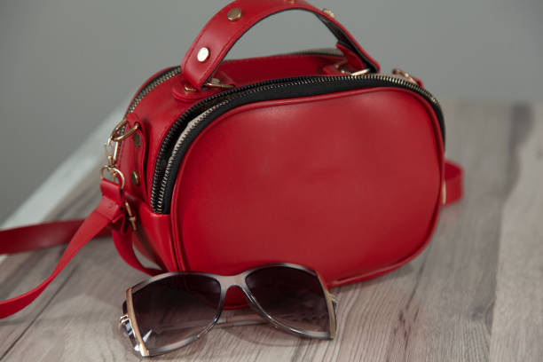 woman bag with sunglasses on the white table