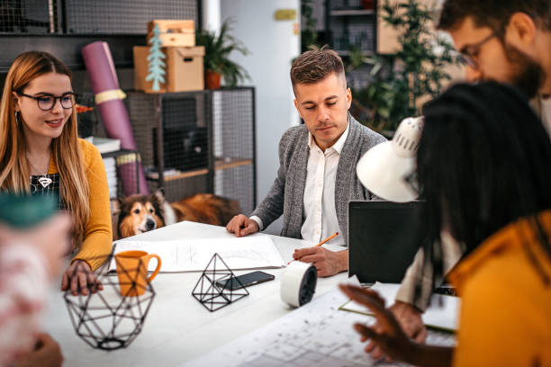 istock Business colleagues analyzing blueprint at office 1211396408