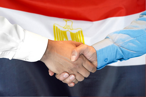 Business handshake on Egypt flag background. Men shaking hands and Egypt flag on background. Support concept