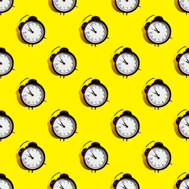 istock Many black classic style alarm clock isolated on yellow background 1211396977