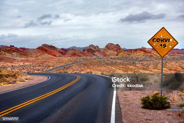 Desert Road Sign With Corvid 19 And Bullets Stock Photo - Download Image Now - Bullet, USA, Winding Road