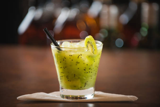 Kiwi caipirinha, decorated with cherry on a wooden table