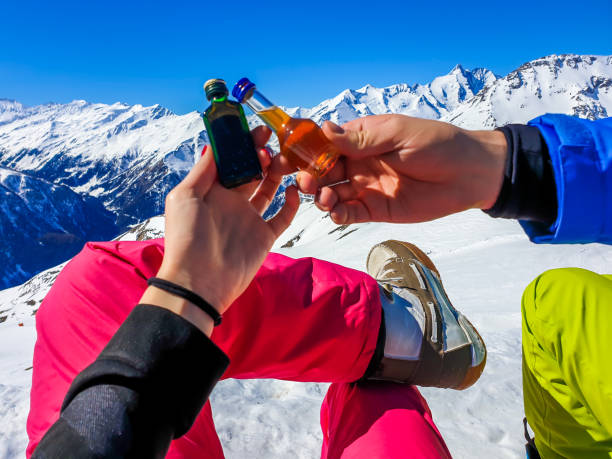heiligenblut - para trzymająca małe butelki alkoholu z górami w tle - apres ski friendship skiing enjoyment zdjęcia i obrazy z banku zdjęć