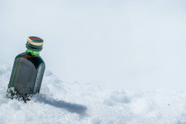 heiligenblut - a little bottle of liquor placed on a fresh snow - ski resort winter sport apres ski ski slope imagens e fotografias de stock