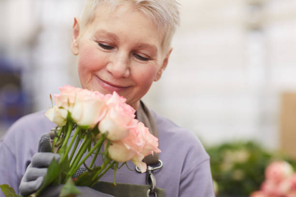 istock Mature woman with roses 1211404977
