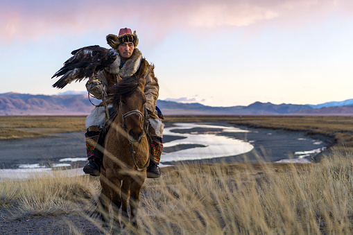 Portrait of eagle hunter on horse in steppe  in Mongolia