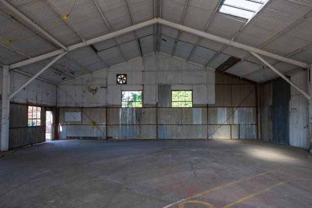 istock Empty warehouse with corrugated tin walls, steel construction and concrete floor 1211406623